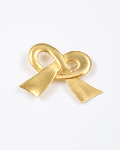 Gold tone brushed metal bow brooch