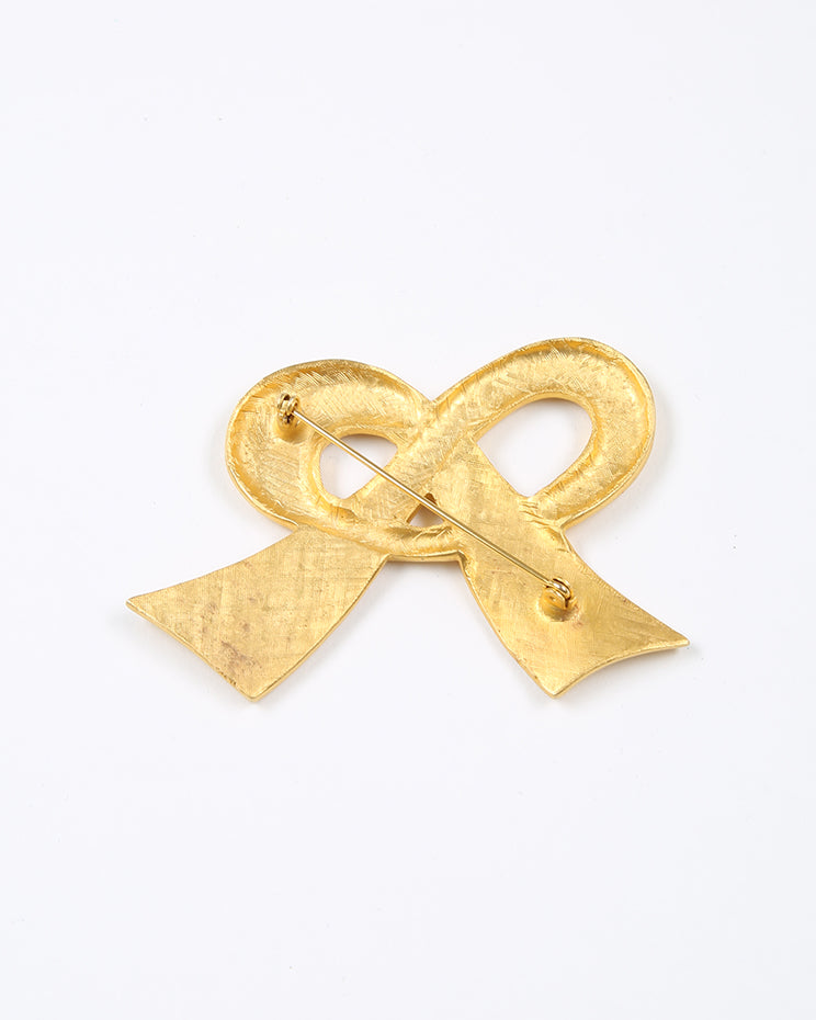 Gold tone brushed metal bow brooch