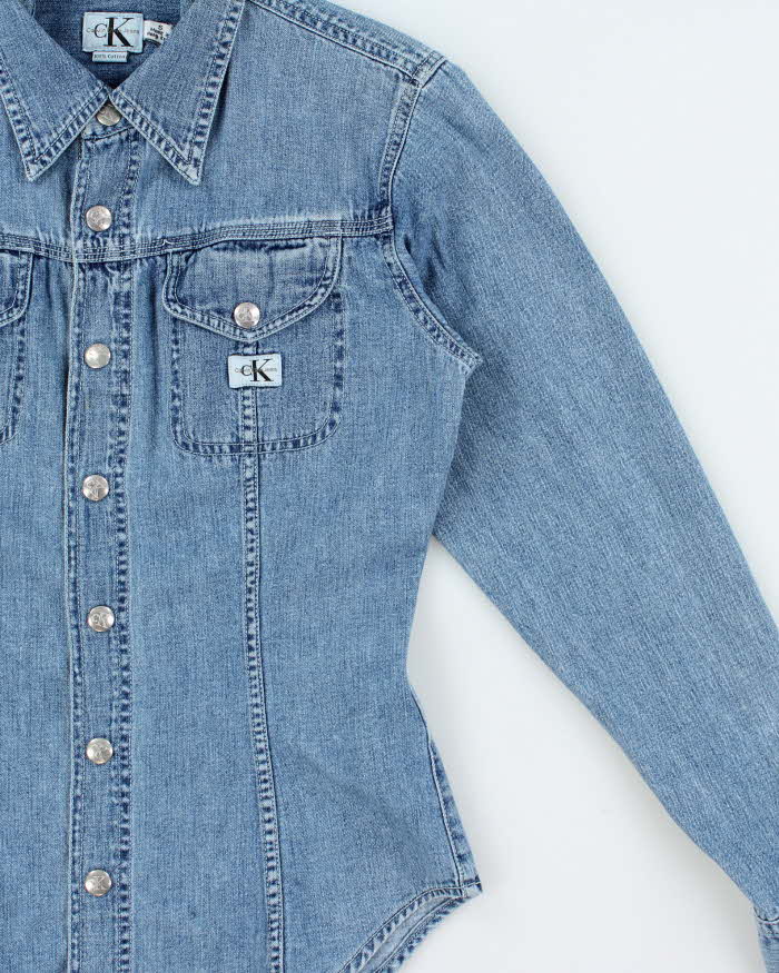Vintage 1990s Calvin Klein Women's Light Wash Denim Snap Button Long Sleeve Shirt - S